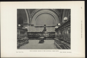 Schwarze und weiße Fotografie des Bankettsaals der National Park Bank in New York City, mit Tischen, Lampen, einer Wanduhr und Text am unteren Rand.