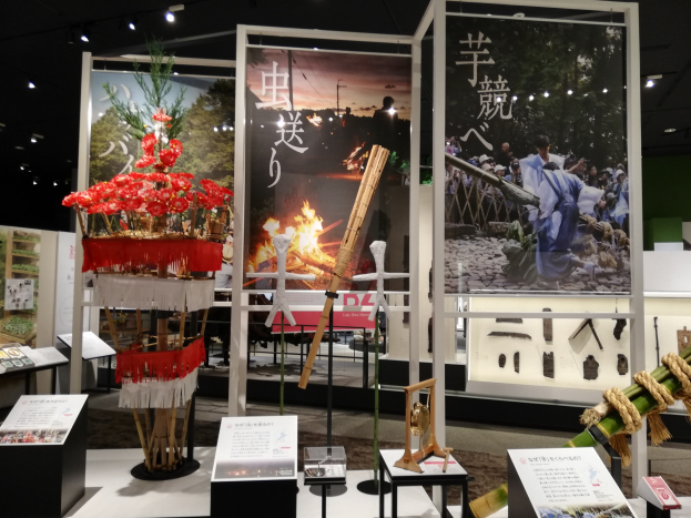 Ein unordentlicher Ausstellungsraum mit verschiedenen Displaytafeln, Ständen und Gegenständen, mit beleuchteter Decke und Hintergrundtafeln mit Bildern und Text bei der Tokyo Toy Fair 2019.