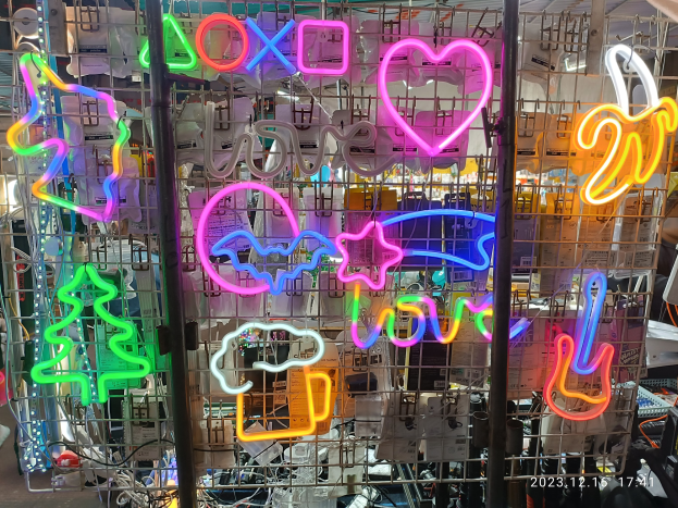 Ein Ladeneinrichtungsbild mit zahlreichen farbig beleuchteten Neon-Schildern, die von der Decke hängen und ein lebhaftes Display schaffen.