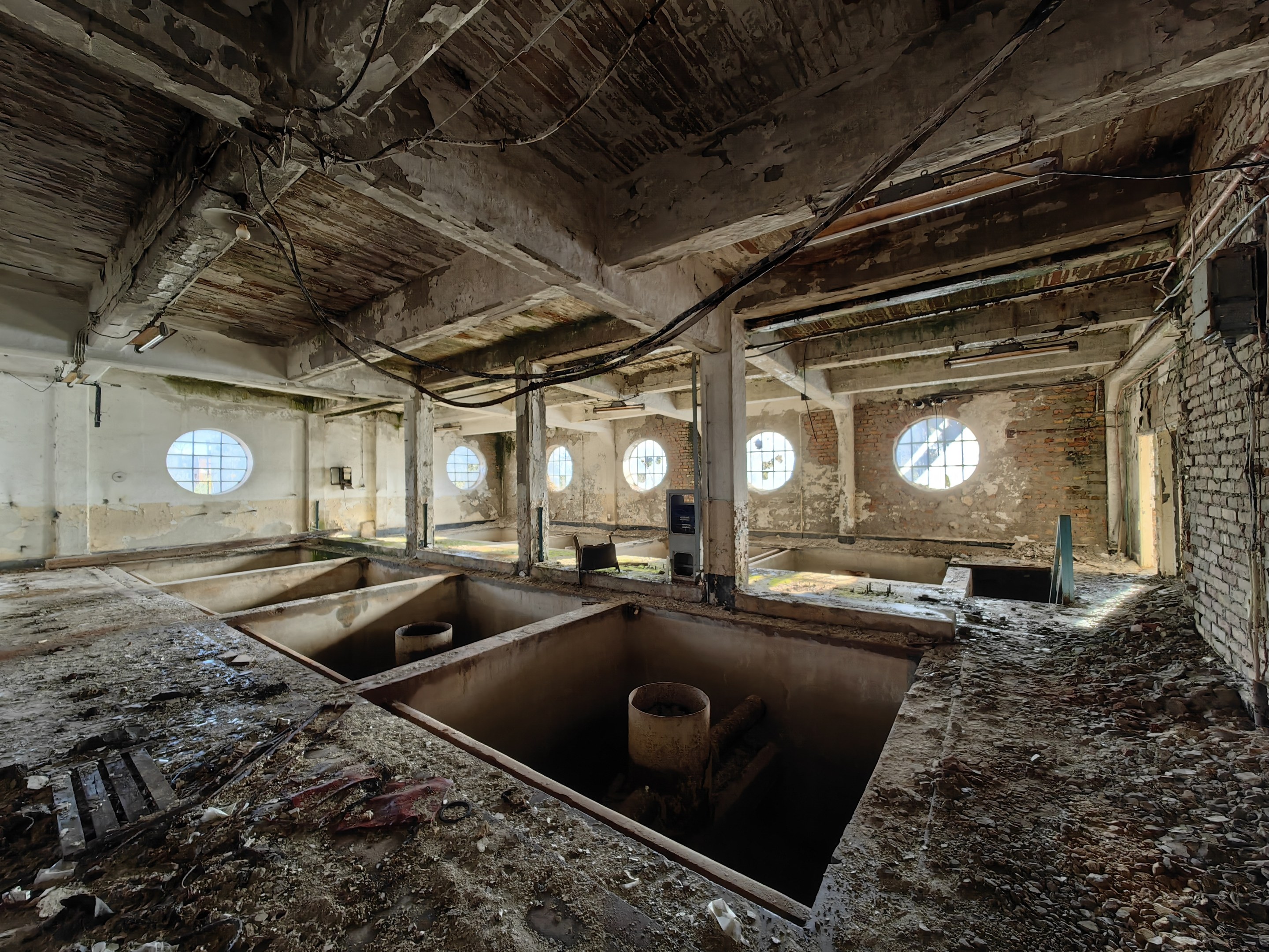 Verlassenes Gebäudeinnere im Sperrgebiet von Tschernobyl mit verstreuten Trümmern, freiliegenden Wänden, Decke und Bauelementen.