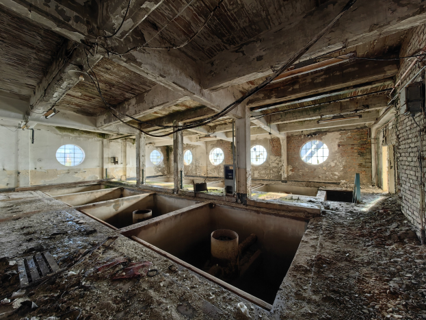 Verlassenes Gebäudeinnere im Sperrgebiet von Tschernobyl mit verstreuten Trümmern, freiliegenden Wänden, Decke und Bauelementen.