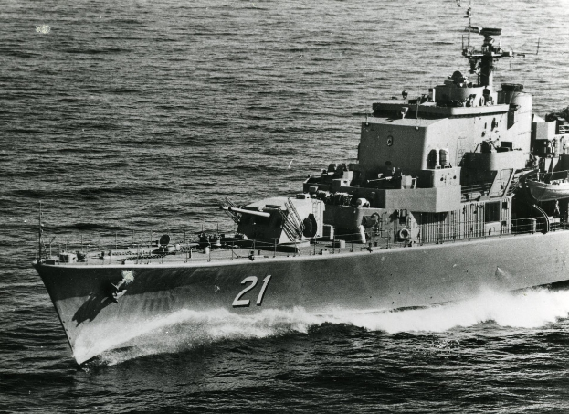 Ein Schwarz-Weiß-Foto eines großen Lenkwaffen-Fregatters mit einer Nummer an der Seite, das auf dem Wasser fährt.