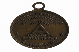 Bronze-Medaille mit 'Banquets Socialistes' eingraviert vor weißem Hintergrund.