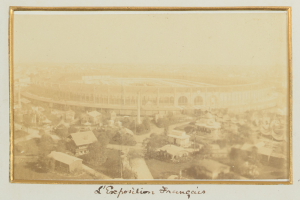 Altes Foto eines Stadions in städtischer Umgebung mit umliegenden Gebäuden, Bäumen und Pfählen, mit Text unten.