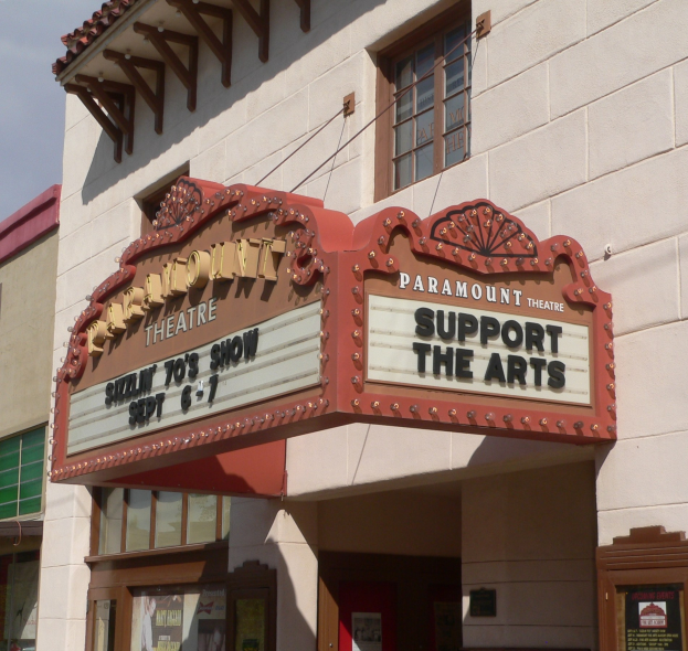Außenansicht des Paramount Theatre in Sacramento, Kalifornien, mit Glasfenstern und -türen und einem "Support the Arts"-Schild unter einem sichtbaren Himmel.