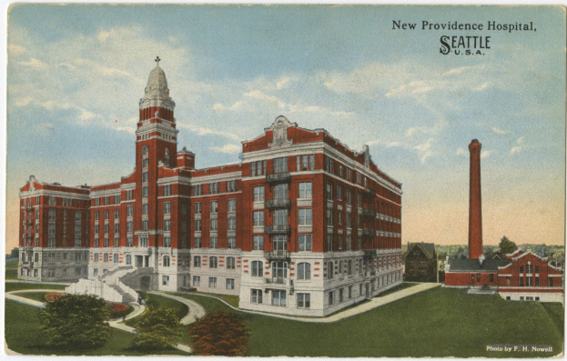 Postkarte des New Providence Hospitals in Seattle, Washington, das ein großes Gebäude mit Fenstern, Treppen mit Geländern, Bäume, Gras und einen bewölkten Himmel zeigt.