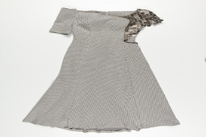 Schwarzes und weißes Paillettenkleid mit engem Oberteil und vollem Rock bis zur Kniehöhe vor einem weißen Hintergrund.