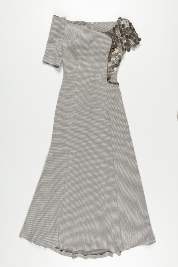 Schwarzes und weißes Paillettenkleid mit engem Oberteil und vollem Rock bis zur Kniehöhe vor einem weißen Hintergrund.