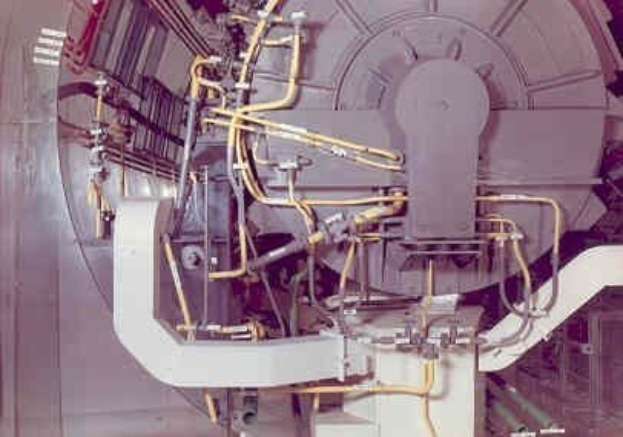 Großes industrielles Beschleunigergerät mit mehreren angeschlossenen Komponenten und Drähten in einem Gebäude.