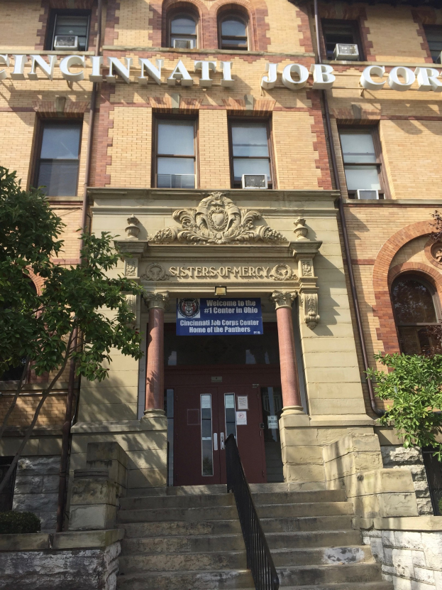 Exterior view of the Cincinnati Job Corps Headquarters building in Cincinnati, Ohio, featuring steps with railings, a name board, windows, doors, pillars, and surrounding trees.